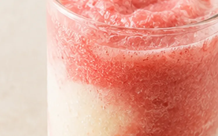 Vaso de granizado de fresa con remolinos de crema