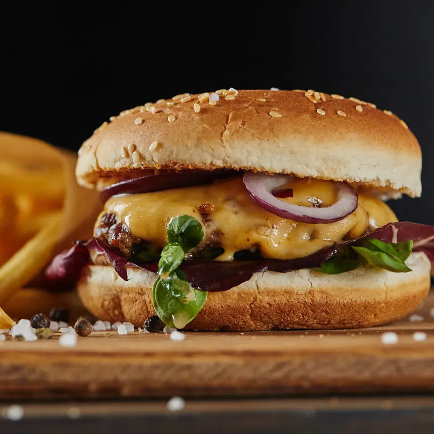 Hamburguesa con queso y papas fritas sobre tabla de madera