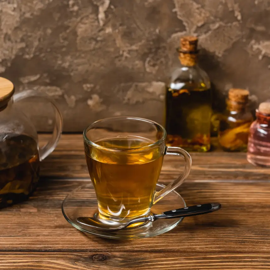 Taza de infusión con frascos de extractos sobre madera