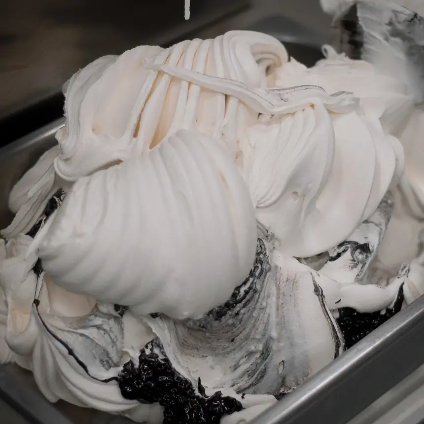 Gelato cremoso trabajado con espátula en una bandeja de acero