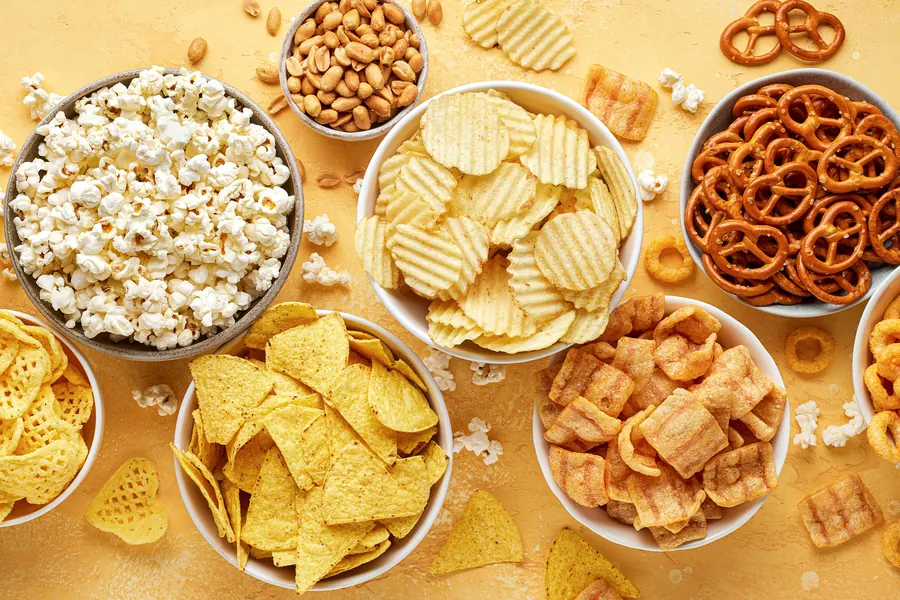 Snacks salados en tazones: papas, nachos, cotufas y pretzels